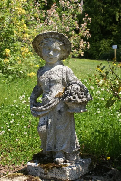 Estatua de una niña llevando una cesta de flores — Foto de Stock