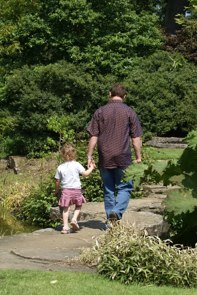 Man and a child leaving a garden — Stock Photo, Image