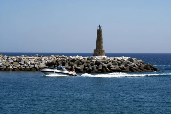 电力船游弋在灯塔前。灯塔，马贝拉，西班牙安达卢西亚自治区 — 图库照片