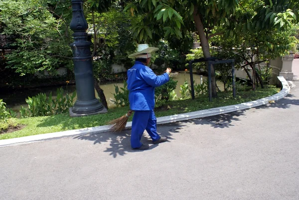 Un pulitore di strada usando una scopa in una strada a Bangkok, Thailandia, Asia — Foto Stock