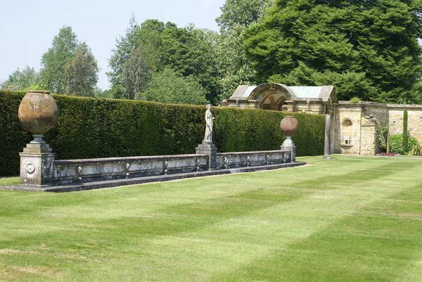 Итальянские терракотовые банки и статуя в саду замка Хивер, Кент, Англия — стоковое фото