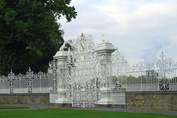 Puerta de hierro forjado blanco adornado con estatuas de perro. Chirk Castle gate, Wrexham, Gales, Inglaterra — Foto de Stock