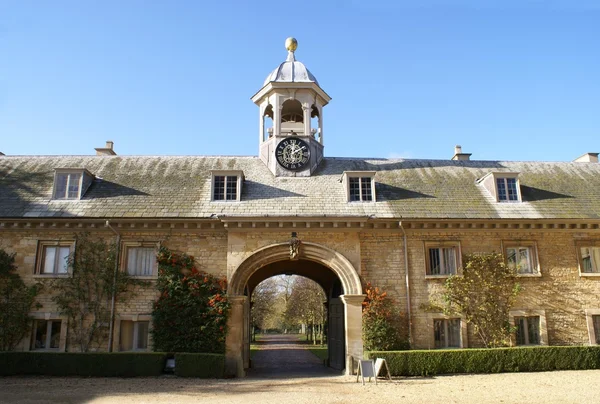 Arched old entrance with sculpture and clock tower — Stock Photo, Image