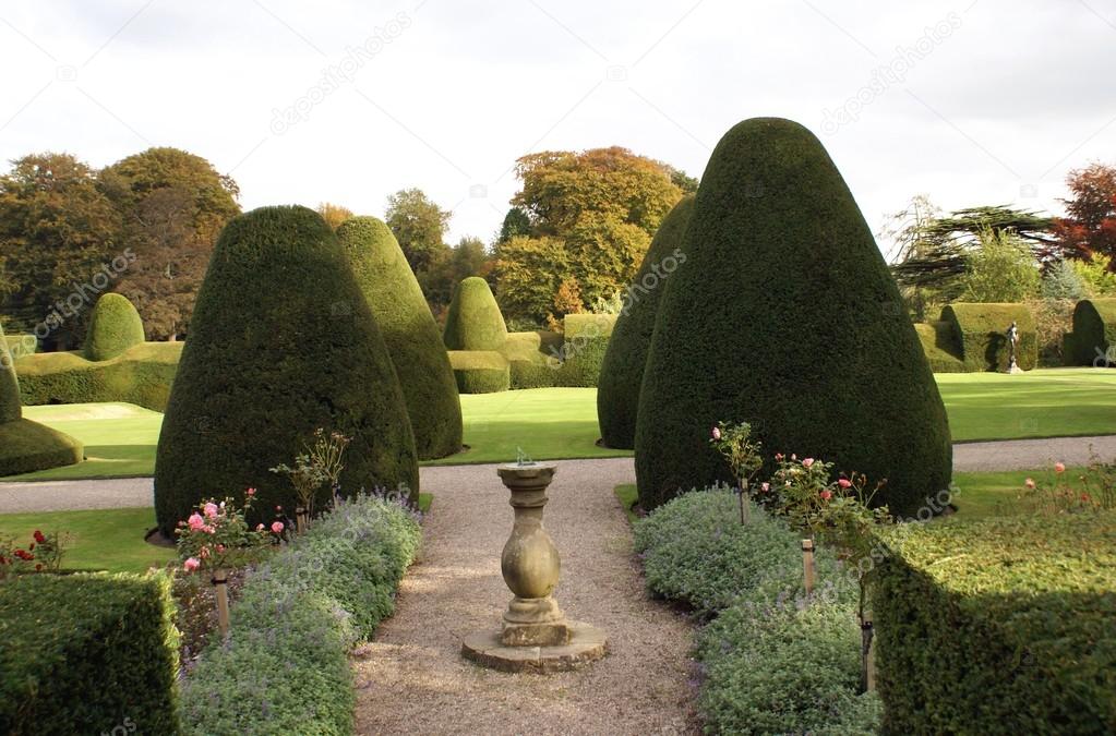 Sundial & pathway of a yew topiary garden. Chirk Castle garden, Wrexham, Wales, England