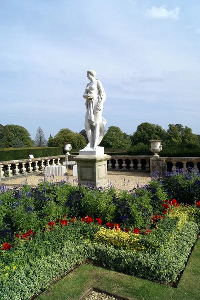 Woman statue on a plinth at a garden — Zdjęcie stockowe