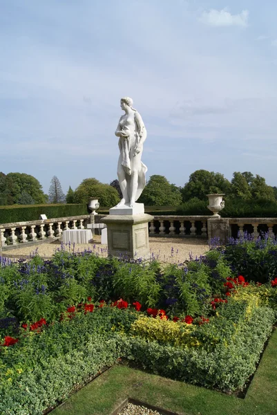 Statue de femme sur un socle dans un jardin coulé — Photo