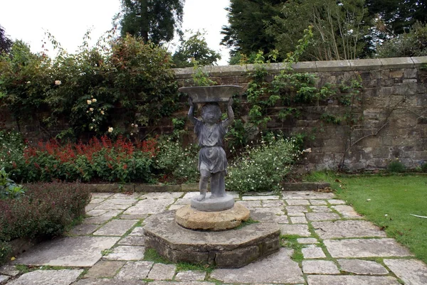 Statue of a boy carrying a bowl in courtyard — Stock Photo, Image