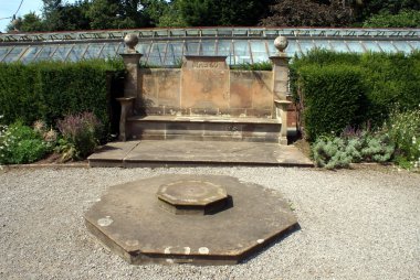 koltuk ve bir sera önünde güneş saati