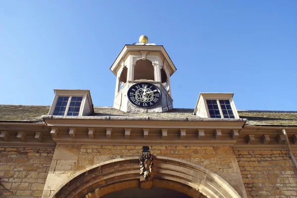 Façade ornée d'une entrée, d'une sculpture, d'une lucarne et d'une tour d'horloge — Photo