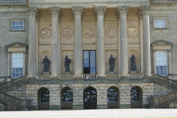 Sierlijke oude gevel met beelden, sculpturen en kolom — Stockfoto