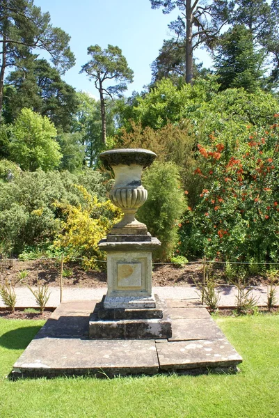 Sculptured urn on a plinth in a garden — Stock Photo, Image