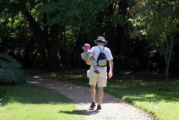 Man carrying his son walking in a park — Stock Photo, Image
