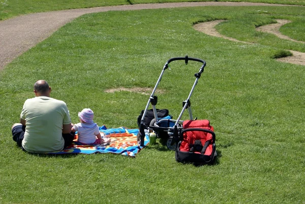 Picnic. single father sitting down with his daughter in a park — Stock Photo, Image