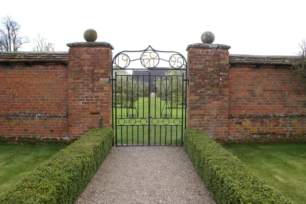 Puerta de hierro forjado de un jardín amurallado — Foto de Stock