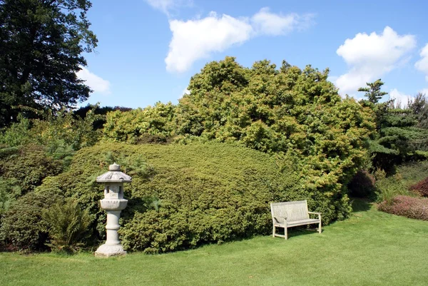 Lâmpada japonesa e banco em um jardim — Fotografia de Stock