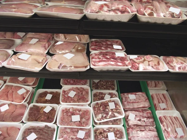 Exposición de carne en una nevera de una carnicería, tienda o mercado — Foto de Stock