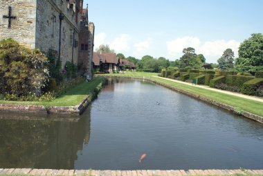 Moated cephe ve bir bahçe heykel çit