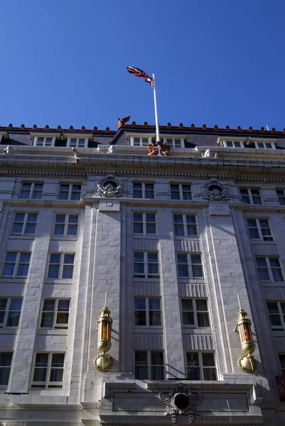 Facade of sculptures, lamps, and Union Jack flag — Stock Photo, Image