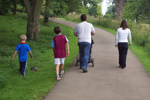 Familjen strosa i en park Stockfoto