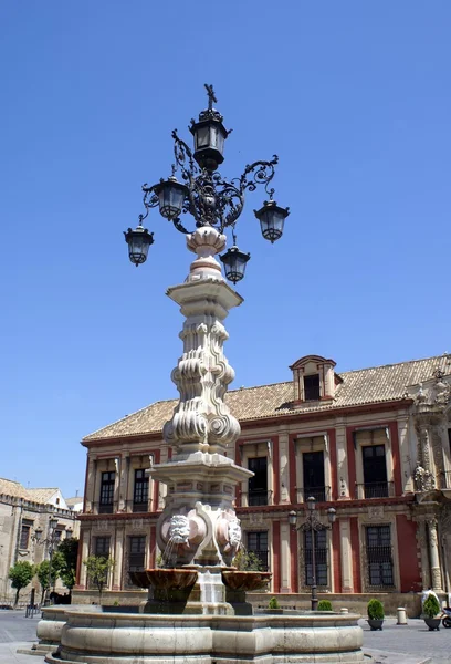 Skulpterade fontän med vintage lampor av katedralen i Sevilla, Spanien — Stockfoto