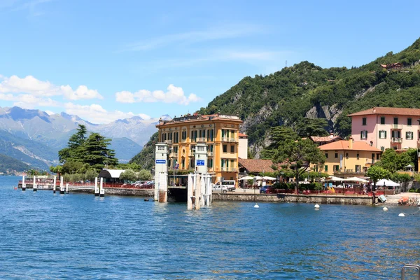 Muelle de transbordadores en el pueblo de Varenna en el lago de Como con montañas en Lombardía, Italia — Foto de Stock