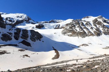 İp ekibi, buzul üzerinde kramponlarla Sexegertenferner 'a doğru Sexegertenspitze ve Avusturya' nın Tyrol Alps şehrinde mavi gökyüzü ile dağ kar panoramasına tırmanıyor.