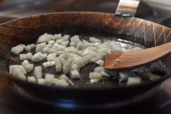 Onions in iron pan with spatula — Stock Photo, Image