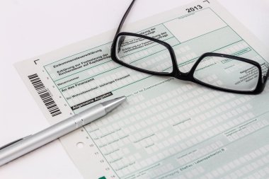 Form of income tax return with ball pen and glasses clipart