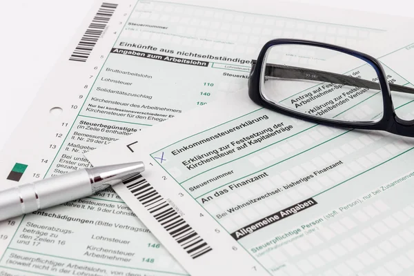 Forma de declaración del impuesto sobre la renta con bolígrafo y gafas —  Fotos de Stock