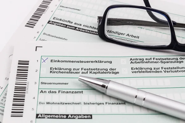 Form of income tax return with ball pen and glasses — Stock Photo, Image