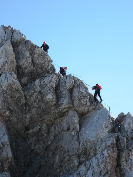 Bergsklättrare klättrar den via ferrata klättring rutten på Watzmann med blå himmel — Stockfoto