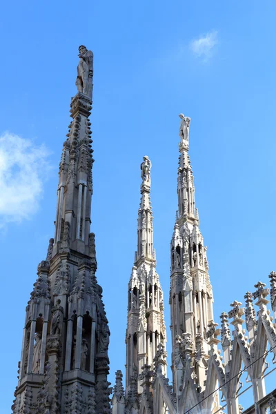 Estatuas sobre la Catedral de Milán y el cielo azul — Foto de Stock