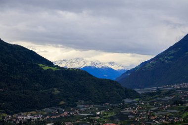 Mountain panorama with snowcapped mountains and summit Laaser Spitze (Orgelspitze) in Ortler Alps and valley Etschtal on a cloudy day in autumn in South Tyrol, Italy