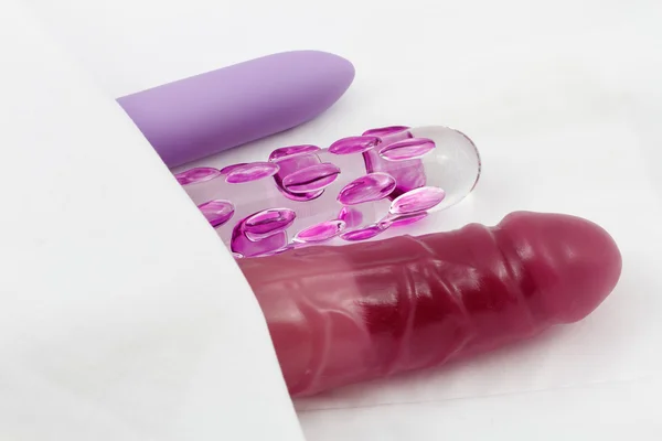Сексуальные игрушки - Стеклянные дилдо и вибраторы в постели — стоковое фото