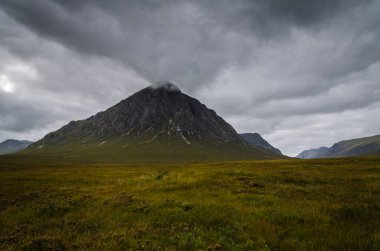 Glen Coe 'daki dağ manzarası Tepelerin üzerinde kara bulutlar asılı, İskoçya, İskoçya