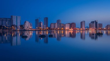 Calpe şehrinin gökyüzü alacakaranlıkta tuz gölüne, Alicante 'ye, Spai' ye yansıdı.