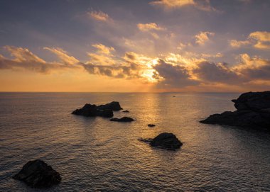 Cabo de Palos 'ta bir uçurumdan güzel bulutlu bir gün doğumu. Güneş deniz suyuna yansıyor, Murcia, İspanya.