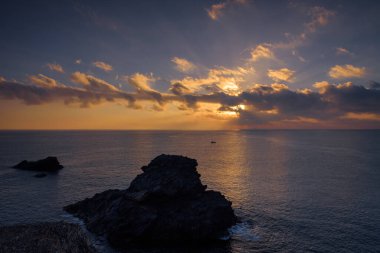 Cabo de Palos 'ta bir uçurumdan güzel bulutlu bir gün doğumu. Güneş deniz suyuna yansıyor, Murcia, İspanya.