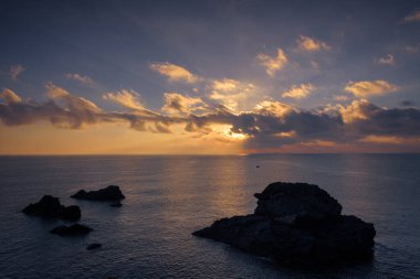 Cabo de Palos 'ta bir uçurumdan güzel bulutlu bir gün doğumu. Güneş deniz suyuna yansıyor, Murcia, İspanya.
