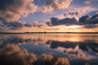 Salinas ve Arenales de San Pedro del Pinatar, Murcia, İspanya Bölgesel Parkı 'nda bulutlarla dolu güzel bir günbatımının tuzlu gölünün suyunun yansıması.