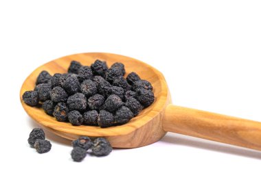 Kurutulmuş Aronia üzümü, Aronia melanocarpa, tahta bir kaşıkta.