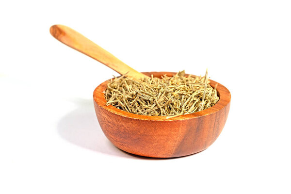 Dried horsetail in a wooden bowl against a white background
