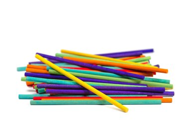 Beyaz arka plana karşı bir sürü renkli tahta çubuk.