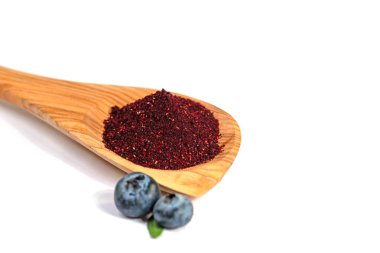 Böğürtlen tozu beyaz bir zemine karşı tahta bir kaşıkta