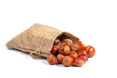 Beyaz bir arka planda jüt çantasındaki fındıklar