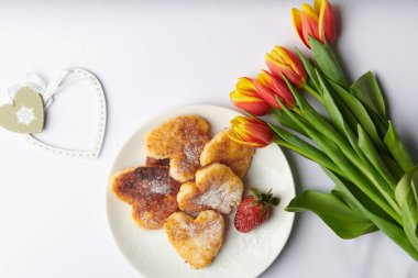 Sonra beyaz bir tabakta kalp şeklinde beyaz bir peynirli kek.