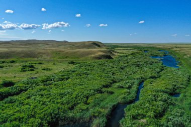 Nehir yatağı mavi gökyüzü ve bulutlu yeşil tarla
