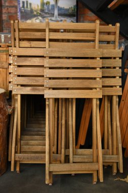 Birleştirilmiş ahşap sandalyeler köşede duruyor.