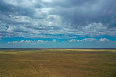 Gökyüzünde bulutlar olan büyük yeşil bir alan.