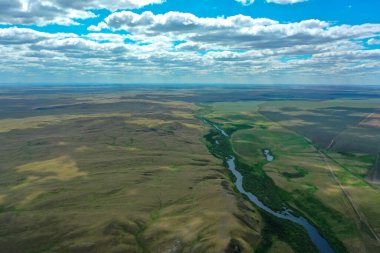 Nehir ve bulutlar ve yemyeşil bir tarlaya yakın.